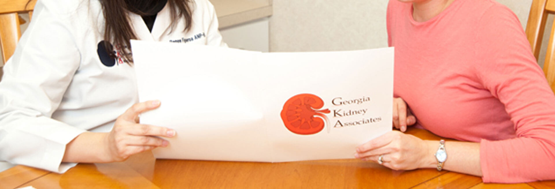 Doctor and patient holding GKA brochure photo for Georgia Kidney Associates | Nephrologists | Nephrology Specialists